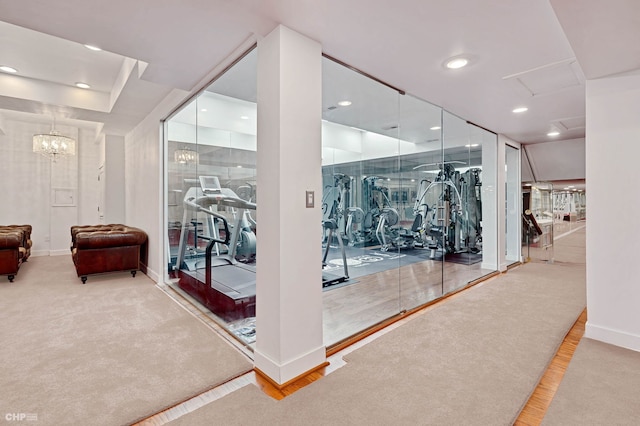 exercise room with attic access, an inviting chandelier, baseboards, and recessed lighting
