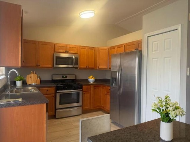 2910 W Clearview Ave, Waukegan, IL 60085 - kitchen featuring brown cabinetry, dark countertops, stainless steel appliances, and a sink