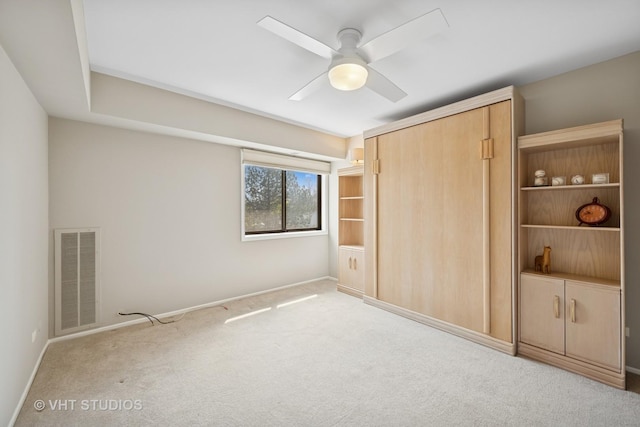 unfurnished bedroom with carpet flooring, a ceiling fan, baseboards, visible vents, and a closet