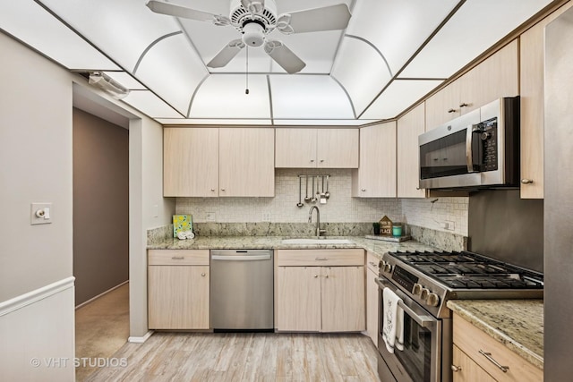 kitchen featuring a sink, light brown cabinetry, a ceiling fan, and stainless steel appliances