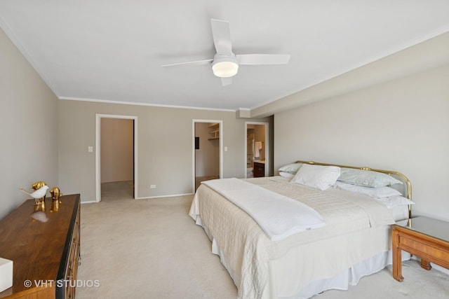 bedroom featuring crown molding, baseboards, ceiling fan, light colored carpet, and a spacious closet