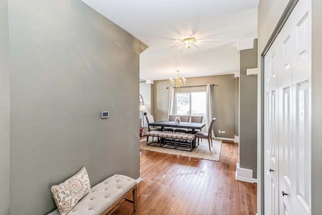 interior space with an inviting chandelier, baseboards, and hardwood / wood-style floors