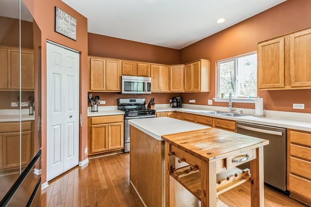 kitchen featuring stainless steel appliances, recessed lighting, a sink, and light wood-style flooring
