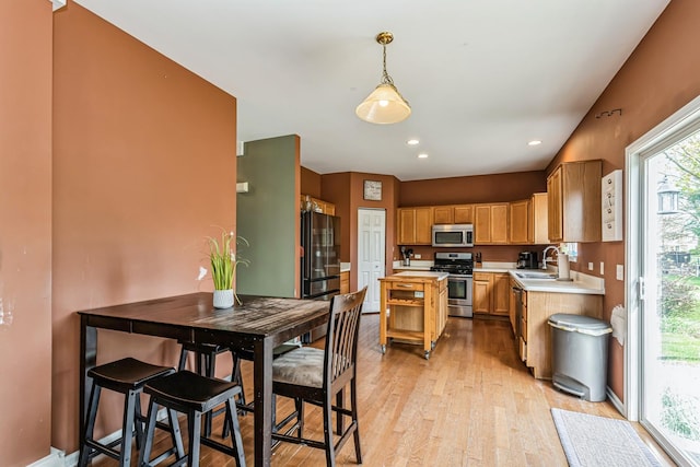 kitchen featuring a sink, light countertops, stainless steel appliances, and light wood finished floors