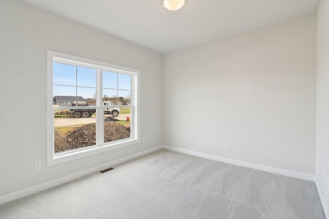 spare room featuring baseboards, carpet flooring, and visible vents