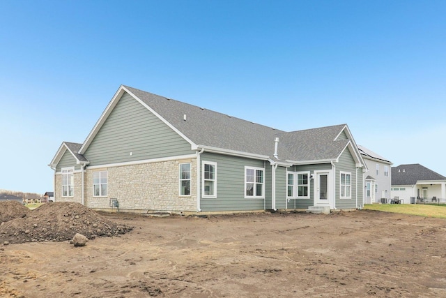 back of house featuring stone siding