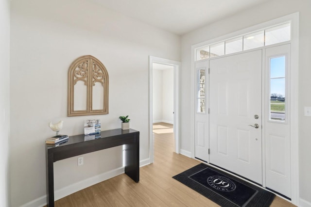 foyer entrance with light wood finished floors, plenty of natural light, and baseboards