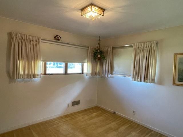 empty room with baseboards and visible vents