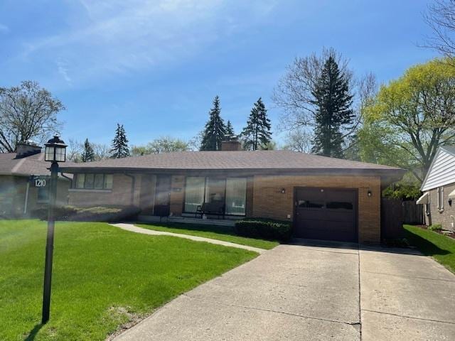 ranch-style house with concrete driveway, brick siding, an attached garage, and a front lawn