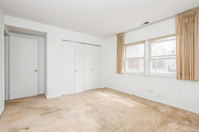 unfurnished bedroom featuring a closet, baseboards, carpet flooring, and visible vents
