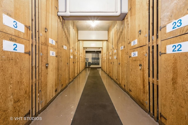 corridor with wood walls and concrete flooring