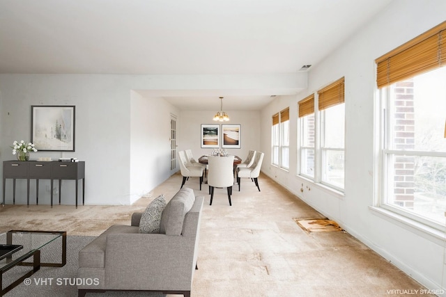 living area featuring a notable chandelier and light carpet