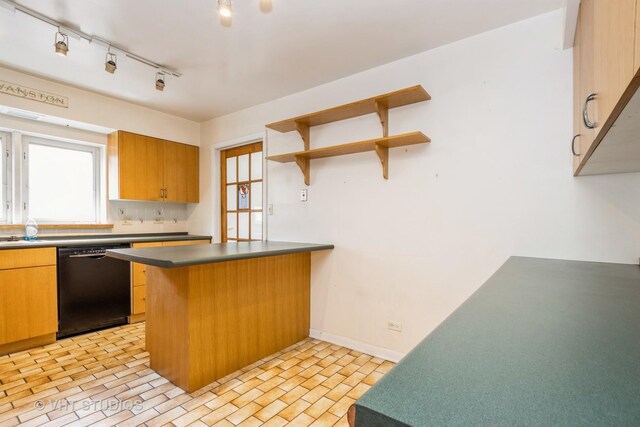 kitchen with dark countertops, open shelves, baseboards, a peninsula, and black dishwasher