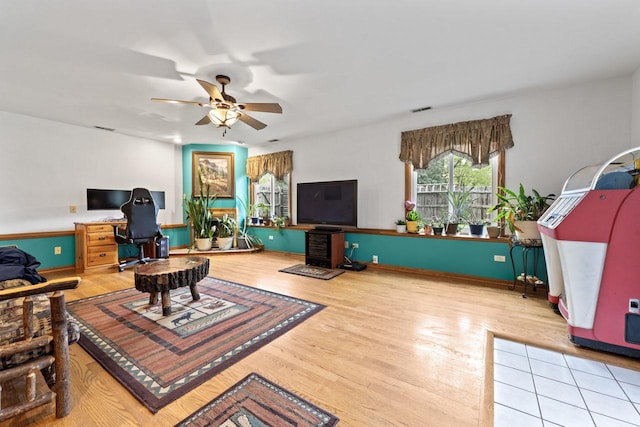 living room featuring a ceiling fan, visible vents, and wood finished floors