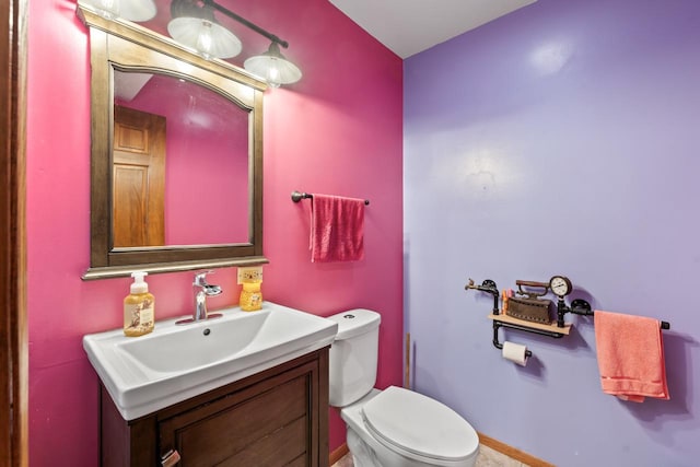 half bathroom with vanity and toilet