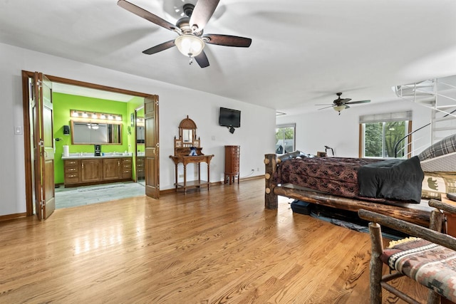 living area with a ceiling fan, baseboards, and light wood finished floors