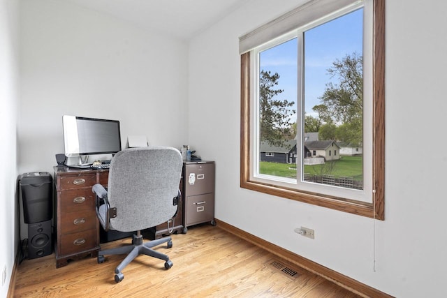 office with light wood-type flooring, baseboards, a wealth of natural light, and visible vents