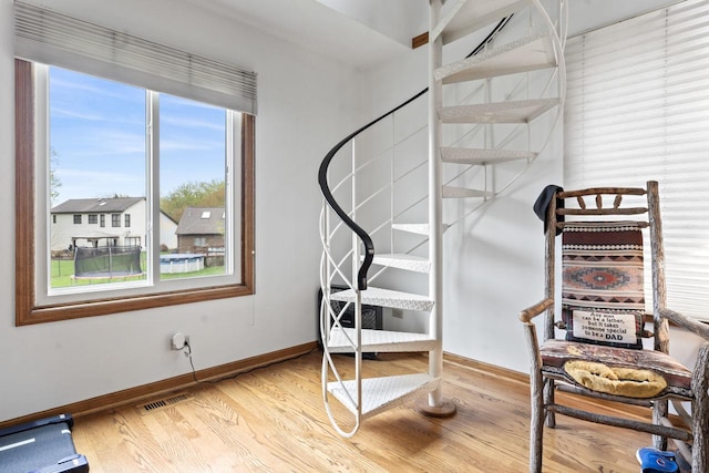 stairs with baseboards, visible vents, and wood finished floors