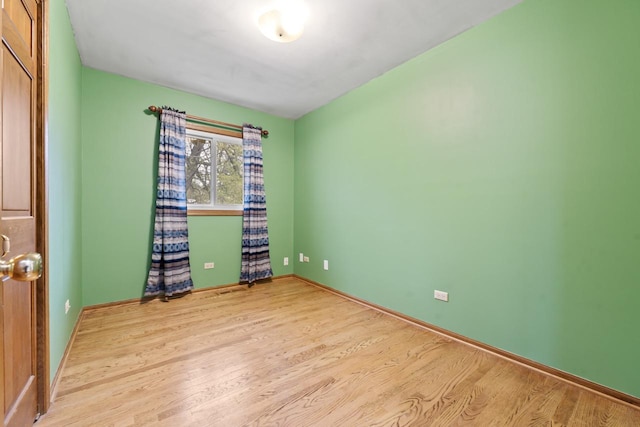 unfurnished room with baseboards and wood finished floors