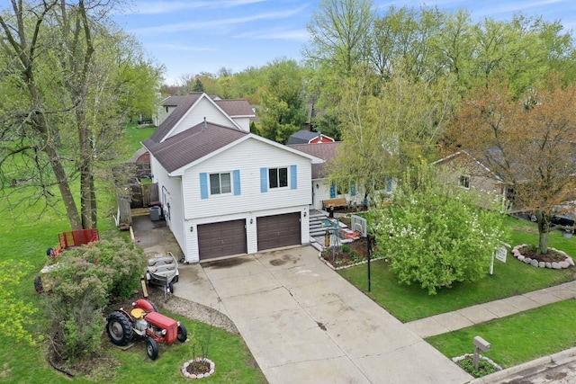 view of front of property with concrete driveway, an attached garage, and a front lawn