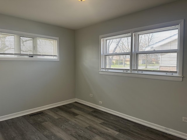 1525 Gordon Ave, Calumet City, IL 60409 - unfurnished room featuring dark wood-type flooring, a healthy amount of sunlight, baseboards, and visible vents