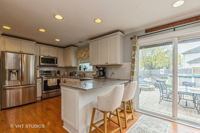 2107 Lawson Blvd, Gurnee, IL 60031 - kitchen with a peninsula, appliances with stainless steel finishes, light stone counters, and recessed lighting
