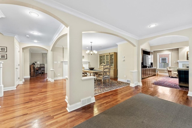 860 Kenton Rd, Deerfield, IL 60015 - foyer entrance featuring light wood finished floors, crown molding, arched walkways, recessed lighting, and a chandelier