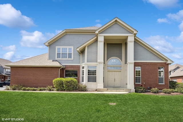 traditional home featuring brick siding, roof with shingles, and a front yard