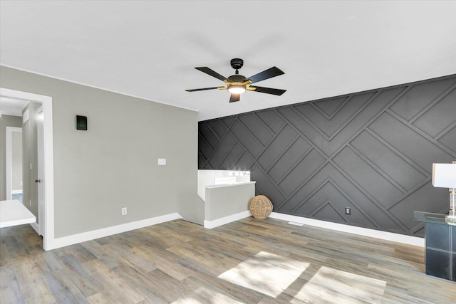 1801 Cindy Lynn St, Urbana, IL 61802 - unfurnished living room featuring baseboards, a ceiling fan, wood finished floors, an accent wall, and a decorative wall