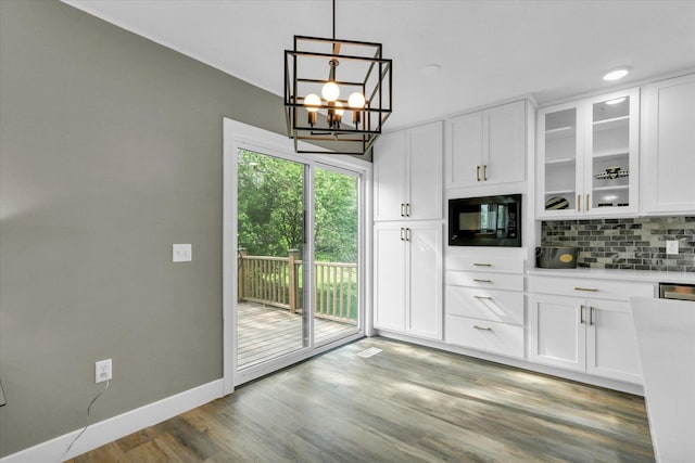1801 Cindy Lynn St, Urbana, IL 61802 - kitchen featuring black microwave, decorative backsplash, white cabinetry, light countertops, and glass insert cabinets