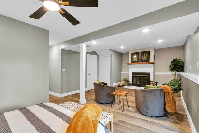 1801 Cindy Lynn St, Urbana, IL 61802 - living room featuring a fireplace, light wood-style flooring, ceiling fan, ornate columns, and baseboards