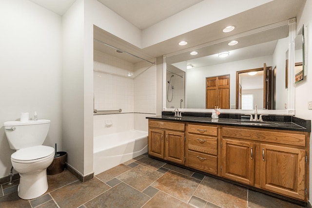 bathroom featuring a sink, toilet, recessed lighting, and double vanity