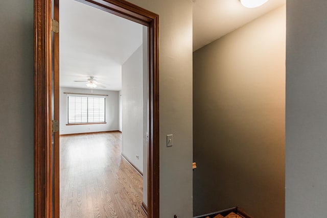 hall featuring baseboards and wood finished floors