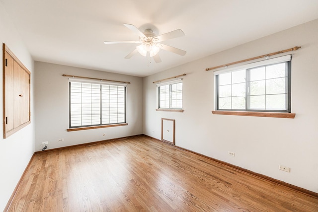 spare room featuring a ceiling fan, baseboards, and light wood-style floors