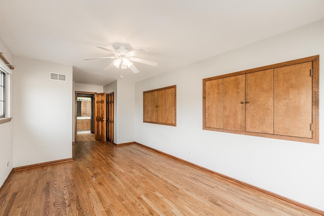 spare room featuring visible vents, a ceiling fan, baseboards, and light wood-type flooring