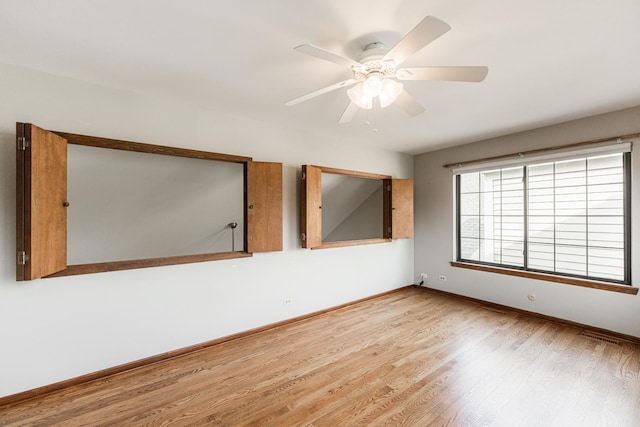 spare room with baseboards, ceiling fan, and wood finished floors