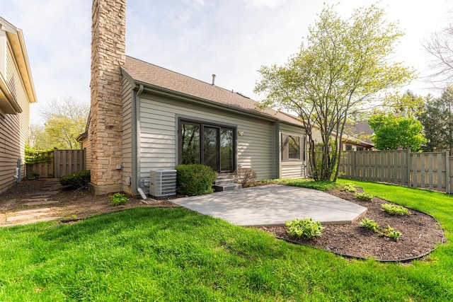 back of property with fence, central AC unit, a chimney, and a patio area