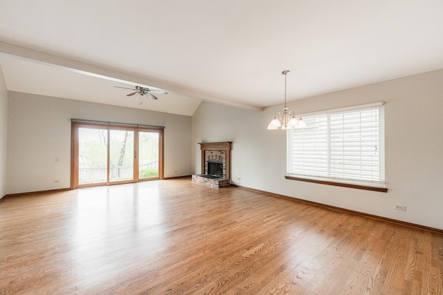 unfurnished living room featuring a fireplace, baseboards, lofted ceiling with beams, ceiling fan with notable chandelier, and light wood-style flooring