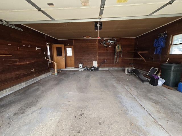 garage with wood walls and a garage door opener