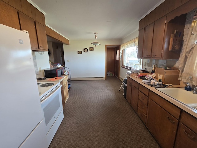 kitchen with a sink, a baseboard heating unit, white appliances, light countertops, and dark carpet