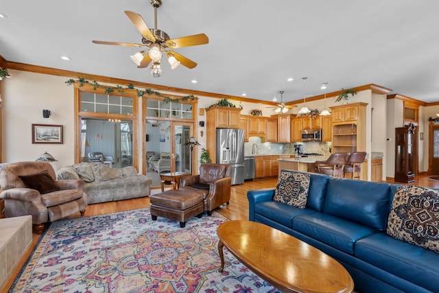 living room with ceiling fan, crown molding, light wood-style flooring, and recessed lighting