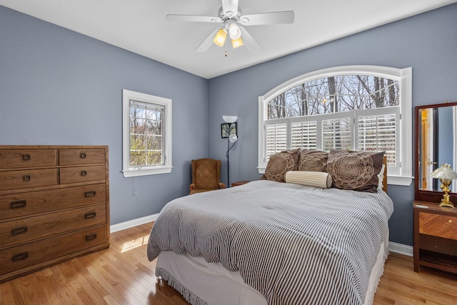 bedroom featuring light wood-style floors, baseboards, and ceiling fan