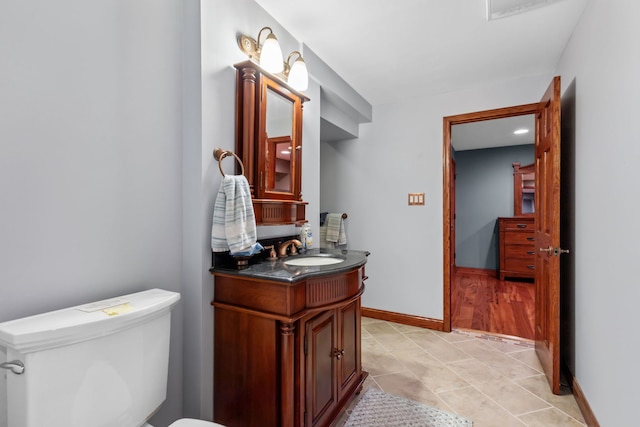 bathroom with toilet, vanity, and tile patterned floors