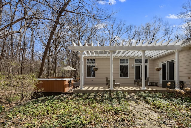 back of property featuring a hot tub, a patio area, a chimney, a deck, and a pergola