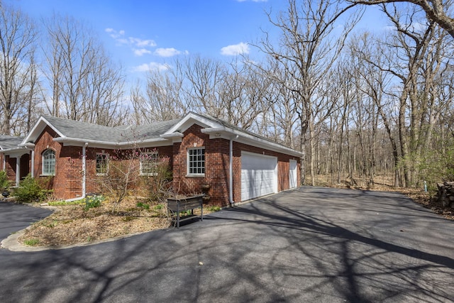 view of home's exterior with brick siding, driveway, and an attached garage