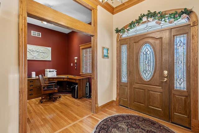 entrance foyer featuring hardwood / wood-style flooring, baseboards, and crown molding