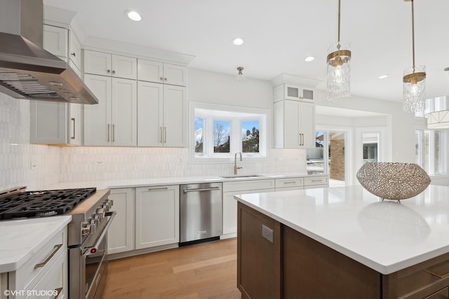 87 Windmill Rd, Orland Park, IL 60467 - kitchen with stainless steel appliances, wall chimney range hood, a sink, light wood-style floors, and decorative backsplash