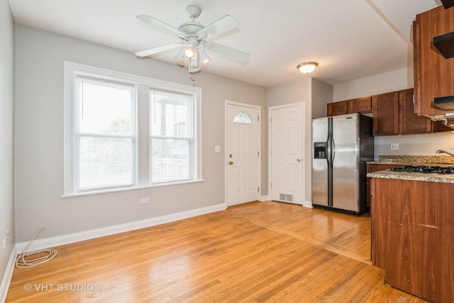 4449 W Sunnyside Ave Unit 2, Chicago, IL 60630 - kitchen featuring stainless steel fridge, light wood finished floors, ceiling fan, and light stone counters