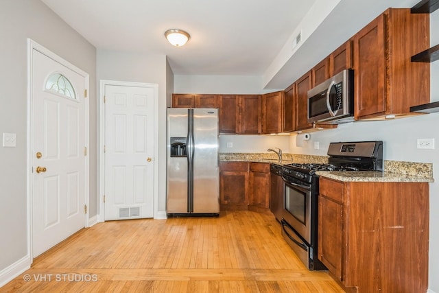 4449 W Sunnyside Ave Unit 2, Chicago, IL 60630 - kitchen featuring stainless steel appliances, light wood-style flooring, and light stone countertops