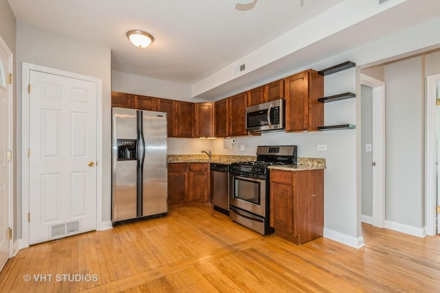 4449 W Sunnyside Ave Unit 2, Chicago, IL 60630 - kitchen featuring stainless steel appliances, light wood-type flooring, open shelves, and light stone countertops